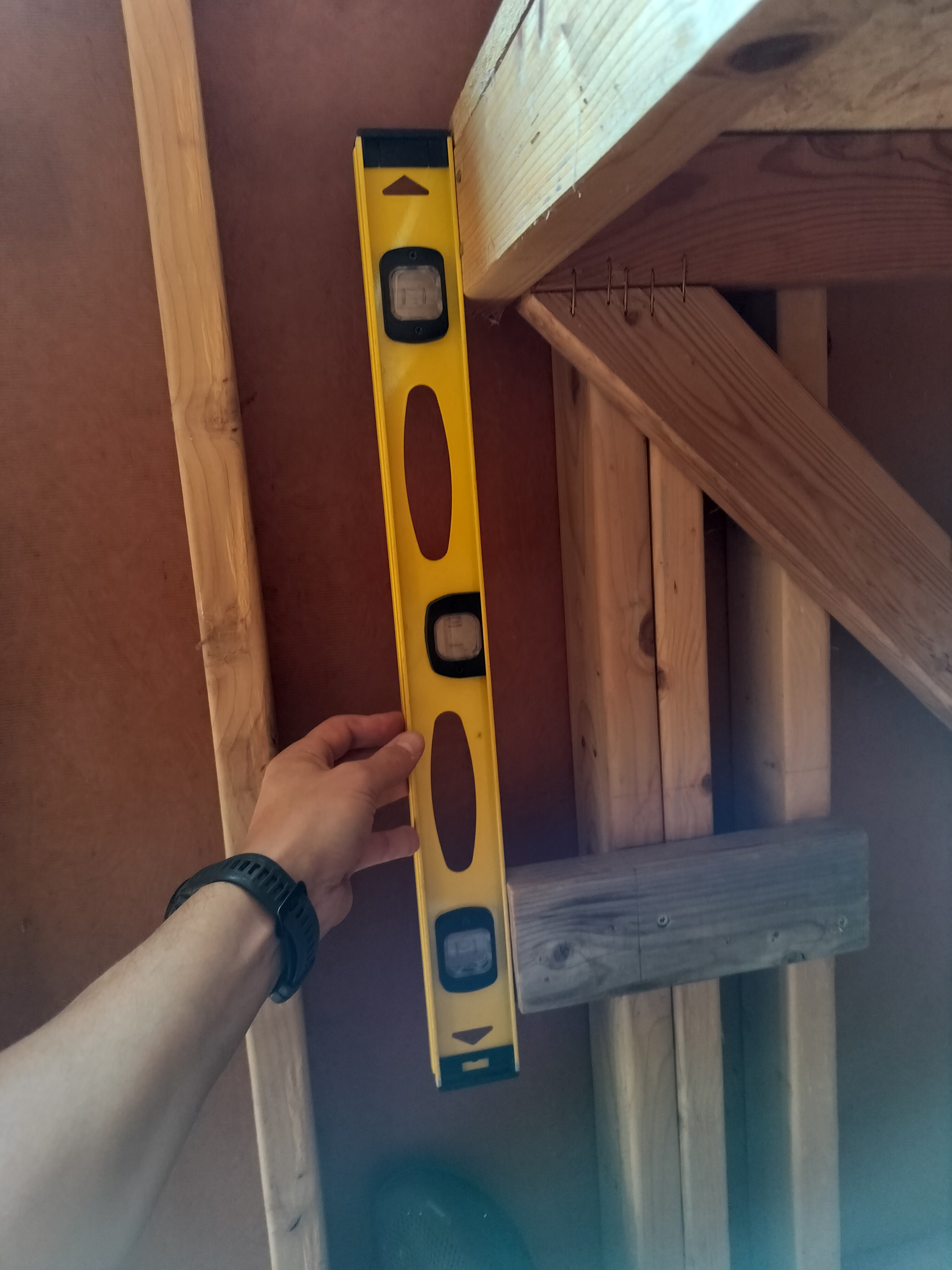 Checking the shelf support for plumb with a level