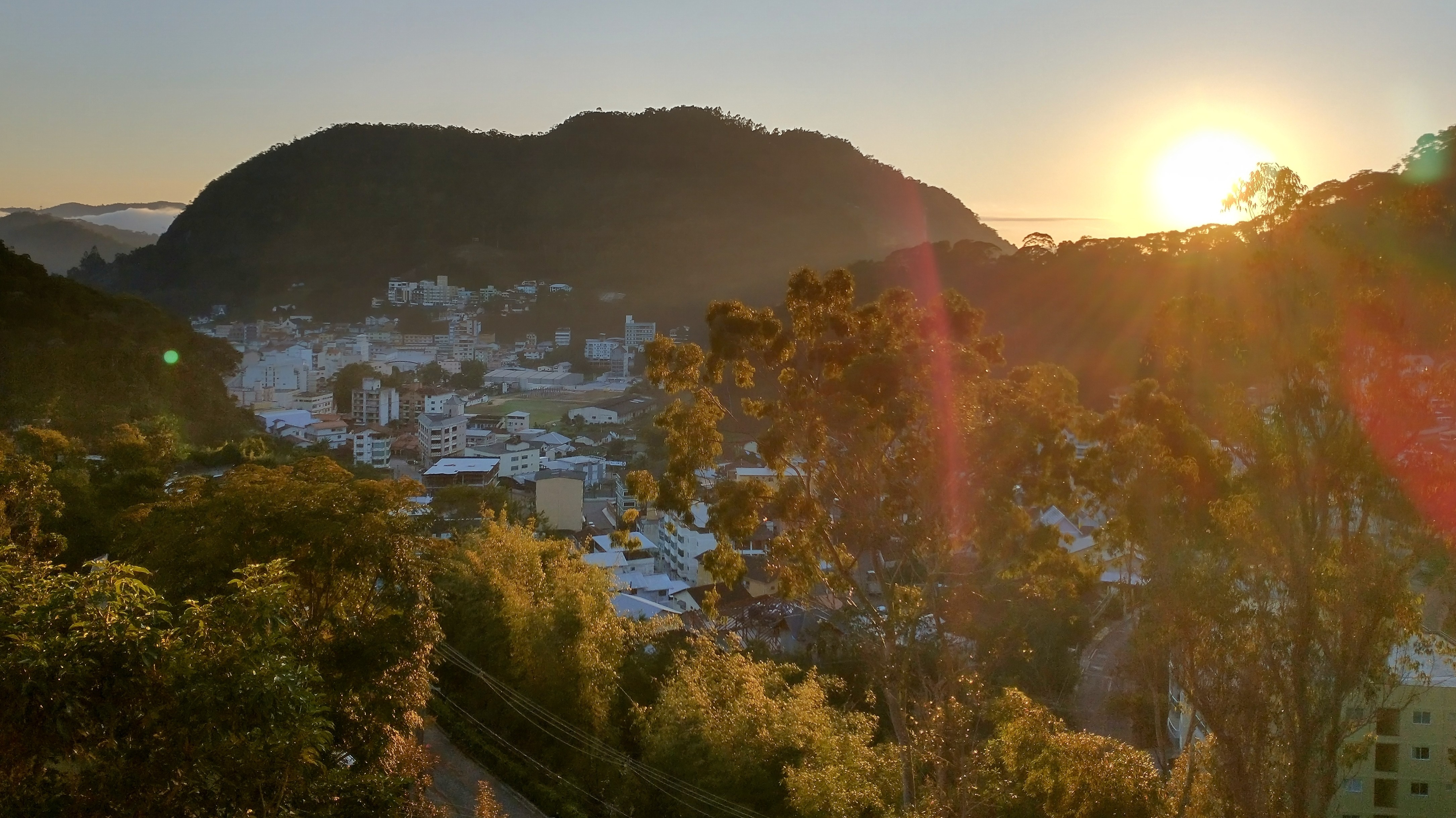 Sunrise over landscape with trees and hills in HDR photography